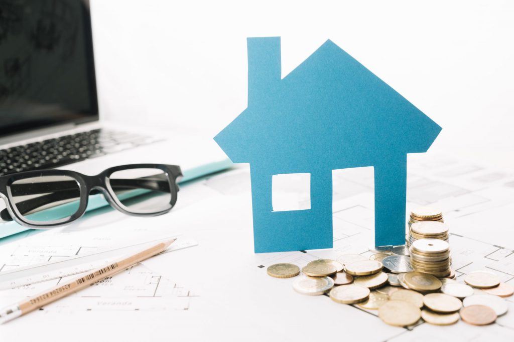 small-house-figurine-coins-laptop